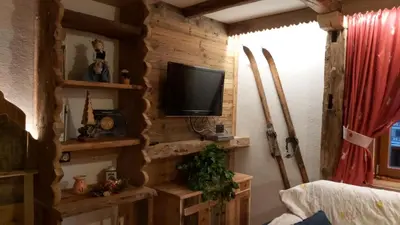 a living room with a tv on a wooden wall at Majon Di Roces in Canazei