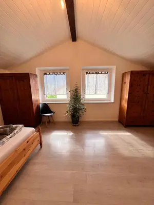 a large room with a bed and two windows at Haus Tauber in Cornaiano