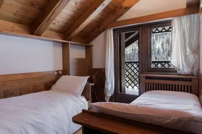 a bedroom with two beds and a window at Appartamento Duplex San Vito di Cadore in San Vito di Cadore