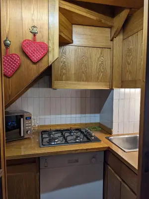 a kitchen with wooden cabinets and a stove top oven at Appartamento Duplex San Vito di Cadore in San Vito di Cadore