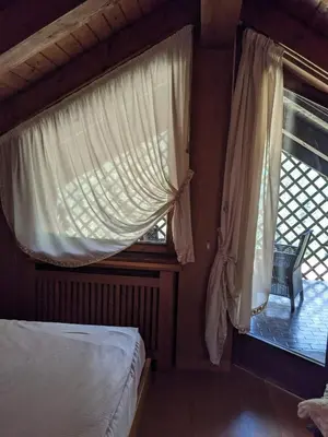 a bedroom with a bed and a window with a chair at Appartamento Duplex San Vito di Cadore in San Vito di Cadore