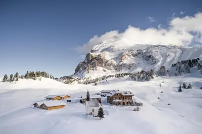 a house in the snow with a mountain in the background at Zallinger Dolomites in Seiser Alm