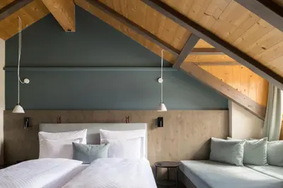 two beds in a room with wooden ceilings at Zallinger Dolomites in Seiser Alm