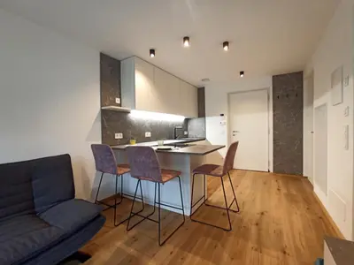 a kitchen and living room with a table and chairs at Nido City Studio in Brixen