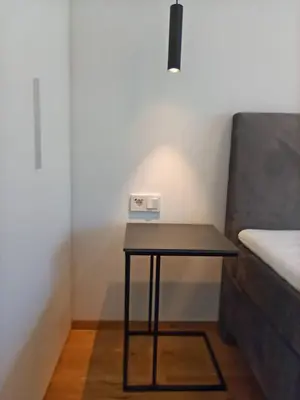 a small black table in a room with a bed at Nido City Studio in Brixen