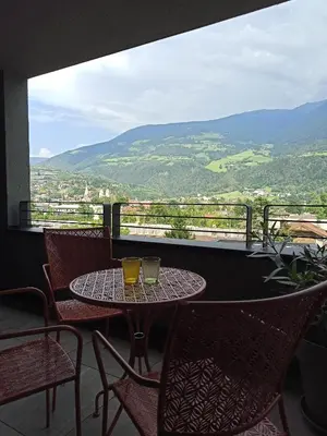 a table and chairs on a balcony with a view at Nido City Studio in Brixen