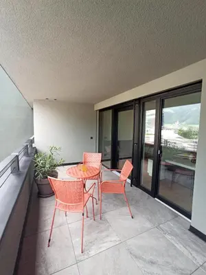 a patio with a table and chairs on a balcony at Nido City Studio in Brixen