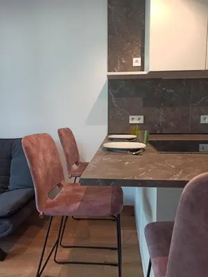 a kitchen with a table and chairs in a room at Nido City Studio in Brixen