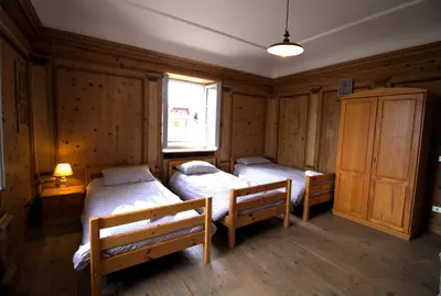 a bedroom with two beds and a window at NIDO SUL CERMIS Affittacamere in Varena