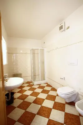 a bathroom with a toilet and a sink and a shower at NIDO SUL CERMIS Affittacamere in Varena
