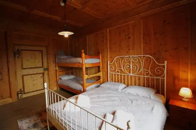 a bedroom with a bed and two bunk beds at NIDO SUL CERMIS Affittacamere in Varena