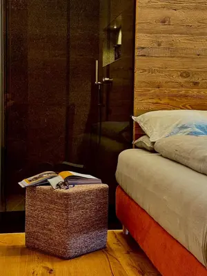 a bedroom with a bed and a table with a book at Lisa Da Pent in Canazei