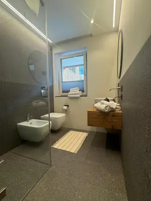 a bathroom with a shower and a toilet and a sink at Lisa Da Pent in Canazei