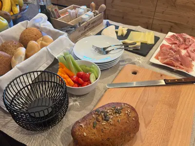 a table with a loaf of bread and a bowl of vegetables at Lisa Da Pent in Canazei