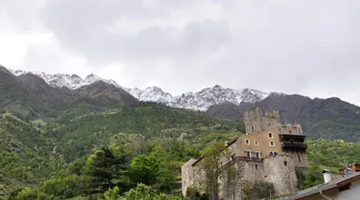 a castle on a hill with mountains in the background at Hotel Weingarten in Naturno