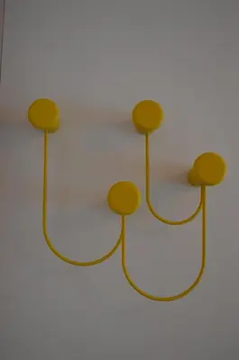 a metal rack with four brown spheres on a white wall at Hotel Weingarten in Naturno