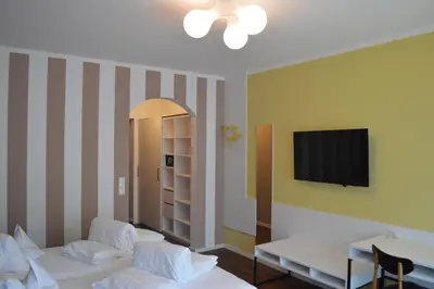 a room with two beds and a tv on a wall at Hotel Weingarten in Naturno