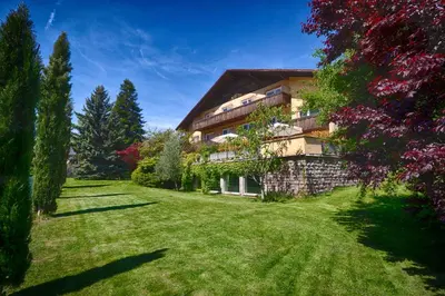 a large house with a grass yard in front of it at Hotel Weingarten in Naturno