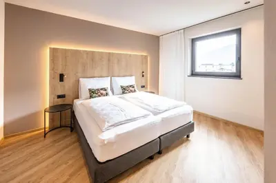 a bedroom with a large bed and a window at Villa Hubertus Luxuria Nova Suites - Adults friendly in Naturno