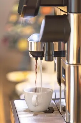 a coffee machine making a bowl in a cup at Villa Hubertus Luxuria Nova Suites - Adults friendly in Naturno