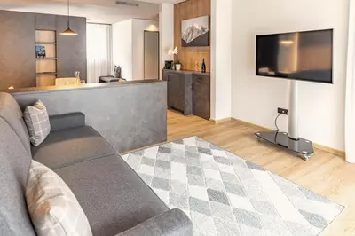 a living room with a couch and a flat screen tv at Villa Hubertus Luxuria Nova Suites - Adults friendly in Naturno