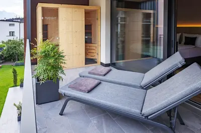 two lounge chairs on a balcony with a plant at Villa Hubertus Luxuria Nova Suites - Adults friendly in Naturno