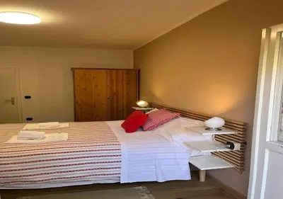 a bedroom with a large bed with red pillows at Casa ai Dossi in Bellamonte