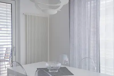 a white dining room with a table and chairs at SWEETHOME TALVERA - con Garage in Bolzano