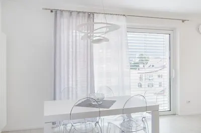 a white dining room with a table and a window at SWEETHOME TALVERA - con Garage in Bolzano
