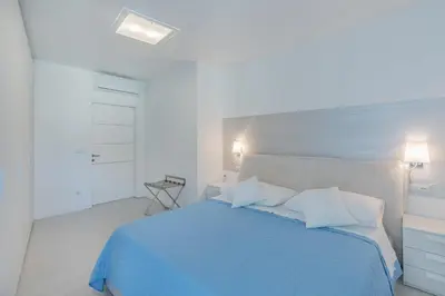 a bedroom with a blue bed with two white pillows at SWEETHOME TALVERA - con Garage in Bolzano
