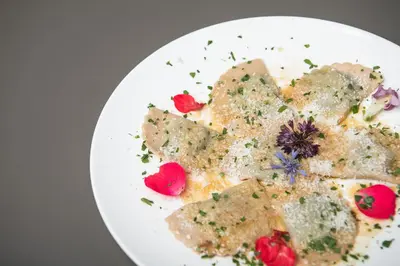 a white plate of food on a table at Hotel Daniel in Selva di Val Gardena
