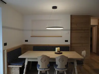 a dining room with a wooden table and chairs at Càbassa Moena in Moena
