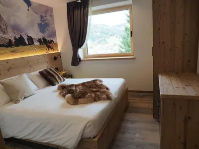 a bedroom with a bed with a teddy bear on it at Càbassa Moena in Moena