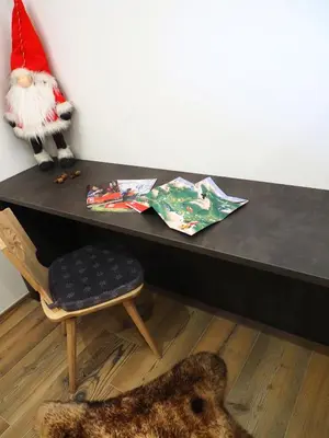 a table with a santa claus toy and a chair at Càbassa Moena in Moena