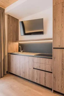 a bathroom with a sink and a tv on a wall at mySHH in Vigo di Fassa