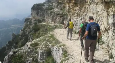 a group of people walking on a mountain trail at Dolomiti Sot i piz in Piaia