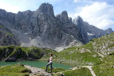a woman standing on a mountain looking at a lake at Dolomiti Sot i piz in Piaia