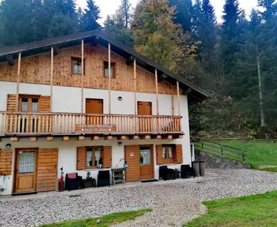 a large wooden house with a balcony at B&B Sass de Mura in Fiera di Primiero