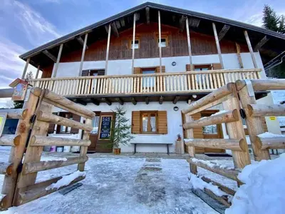 a house with a wooden fence in front of it at B&B Sass de Mura in Fiera di Primiero