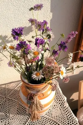 a vase filled with purple and white flowers on a table at B&B Sass de Mura in Fiera di Primiero