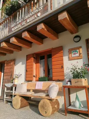 a wooden bench in front of a building at B&B Sass de Mura in Fiera di Primiero