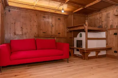 a red couch in a room with a bunk bed at Casa Molino La Stua - El Fornel in Falcade