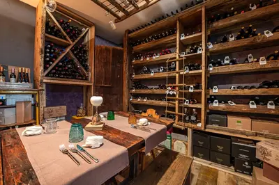 a room with a table and some bottles of wine at Villa Ruggero Wine Hotel in Campitello di Fassa