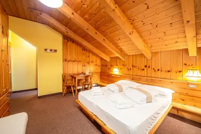 a room with a table and shelves of wine bottles at Villa Ruggero Wine Hotel in Campitello di Fassa