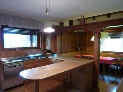a kitchen with a wooden counter top and a table at Villa Pocol - Stayincortina in Cortina dʼAmpezzo