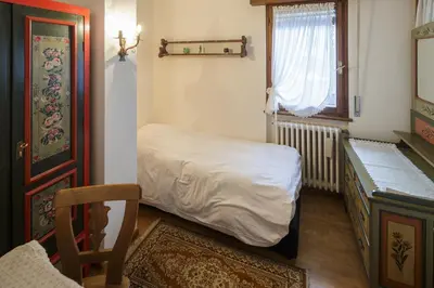 a small bedroom with a bed and a window at Villa Pocol - Stayincortina in Cortina dʼAmpezzo