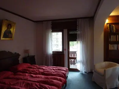 a bedroom with a bed and a window and a chair at Villa Pocol - Stayincortina in Cortina dʼAmpezzo