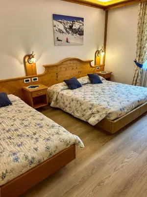 a bedroom with two beds and two night stands at Cesa Bernard - Aloch in Pozza di Fassa