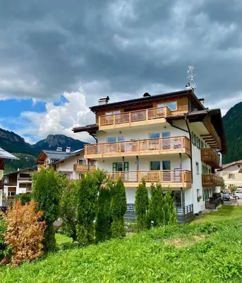 a building with wooden balconies on the side of it at Cesa Bernard - Aloch in Pozza di Fassa