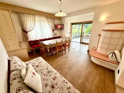 a living room with a bed and a dining room at Cesa Bernard - Aloch in Pozza di Fassa